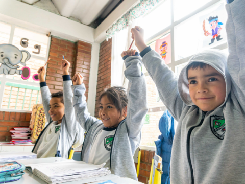 niños alzando las manos